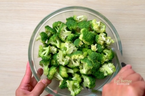 Tossing broccoli with oil